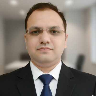 Headshot of Vinay Pandey, Director Global Strategic Sourcing Head at SPIRO, in a dark suit and blue tie against a blurred office background